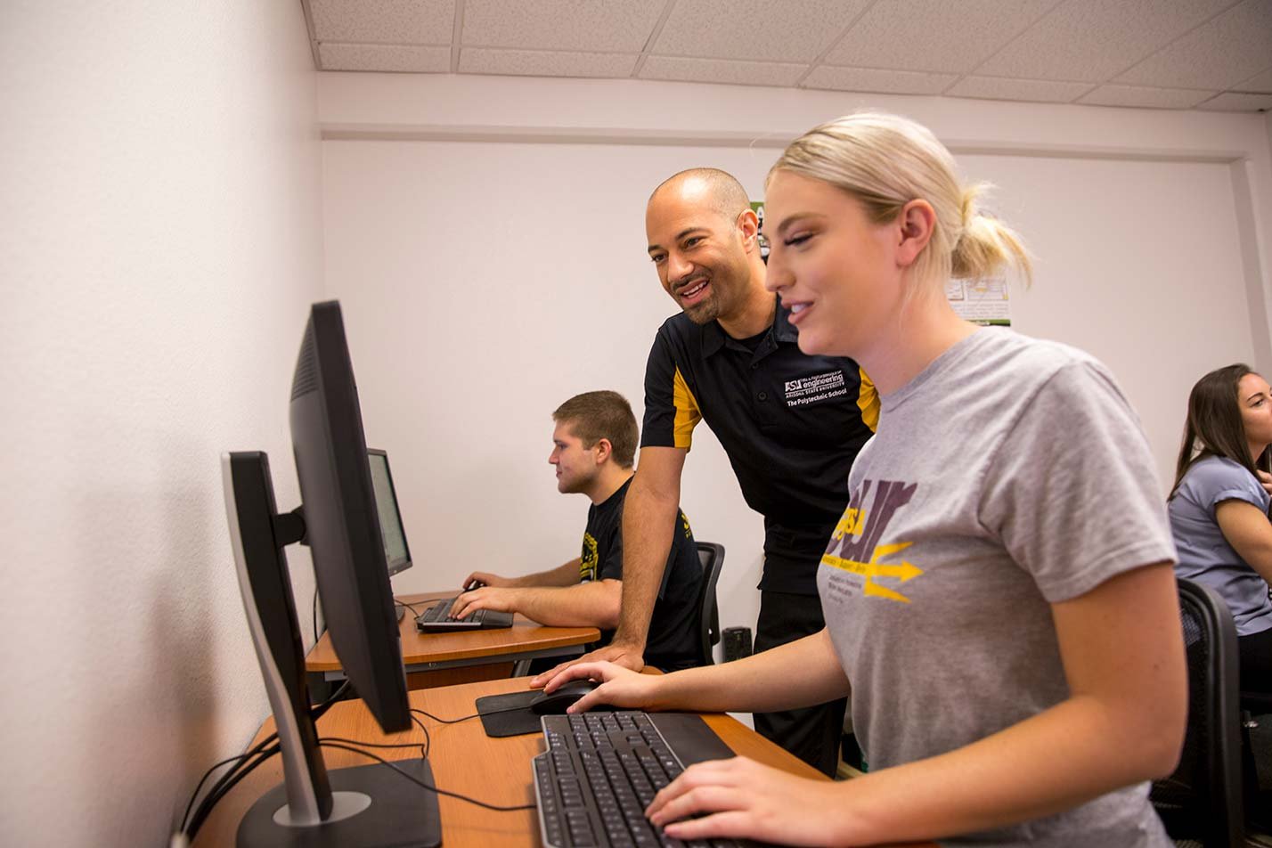 Students engage in collaborative learning at a computer station, showcasing teamwork in ASU's Human Systems Engineering degree.