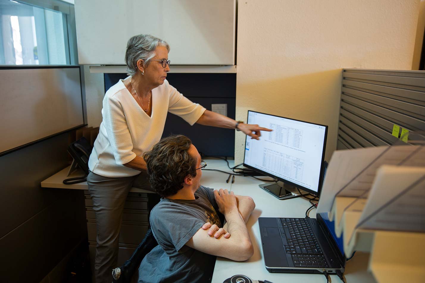 A professor and student engage in data analysis together, showcasing practical skills in ASU's Information Technology (Cybersecurity) program.