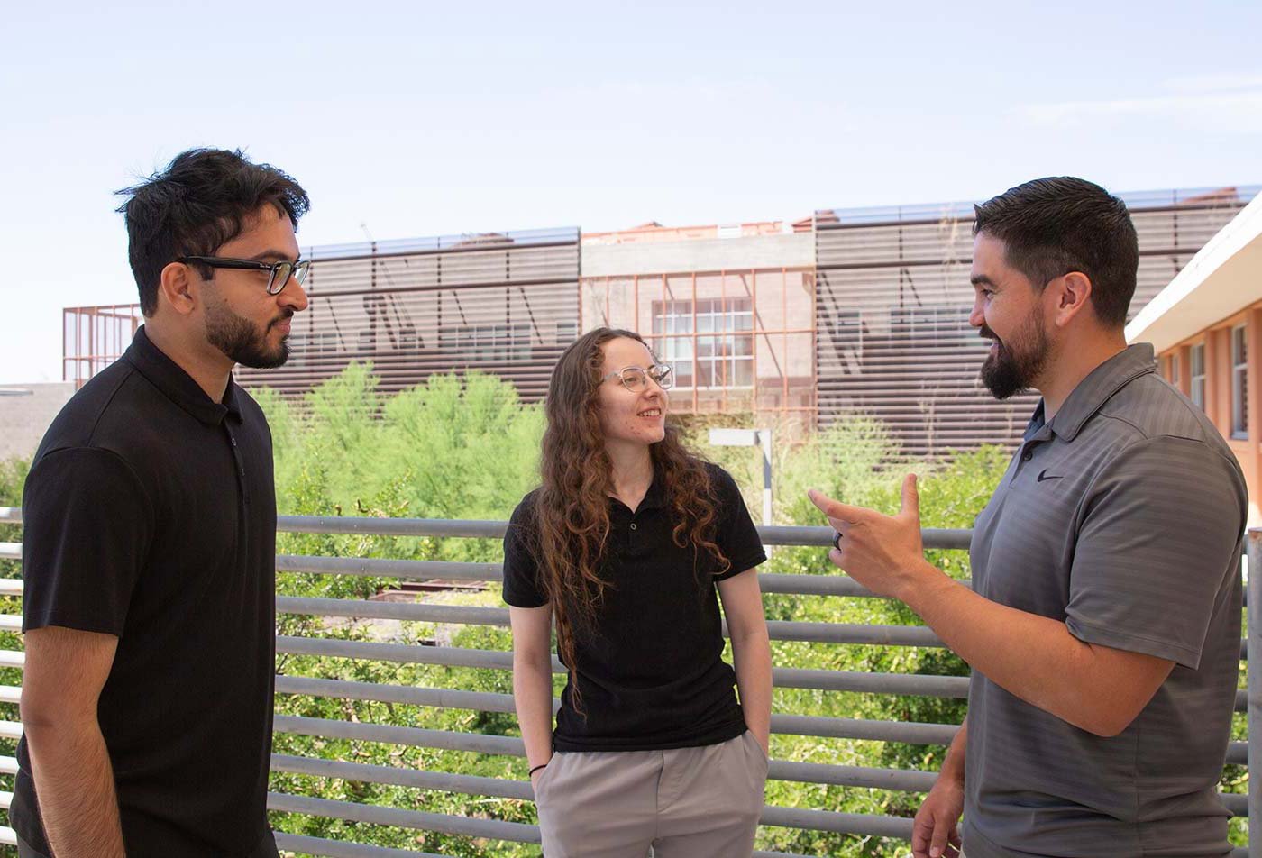 Students discuss technology projects on an outdoor campus patio, highlighting collaboration in ASU's Information Technology, DIT program.