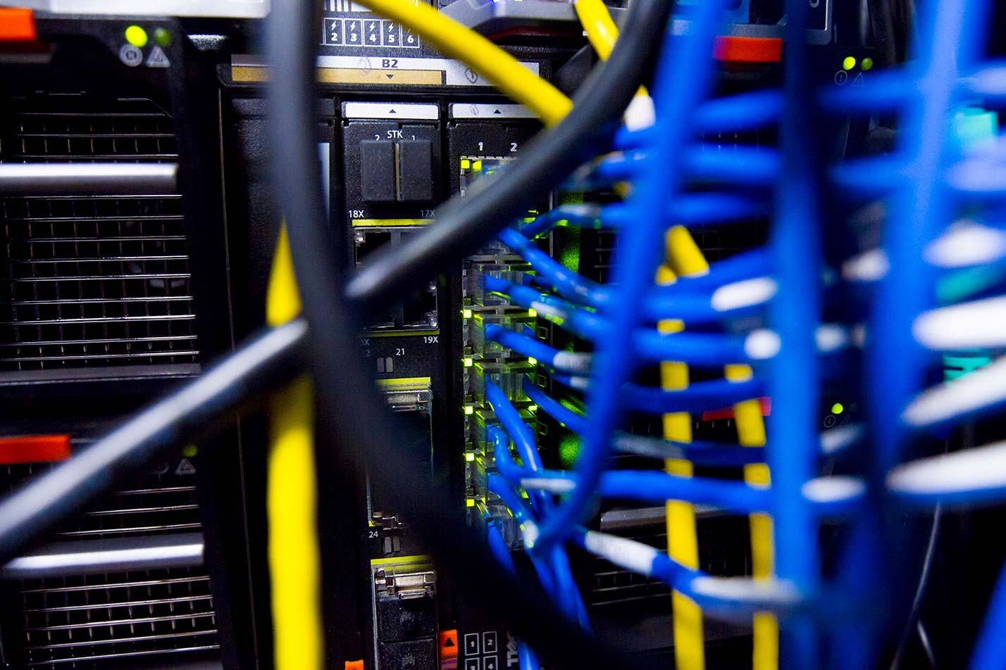 Colorful Cat 5 cables connect to servers, illustrating the technical aspects of ASU's Information Technology (Networking) degree program.