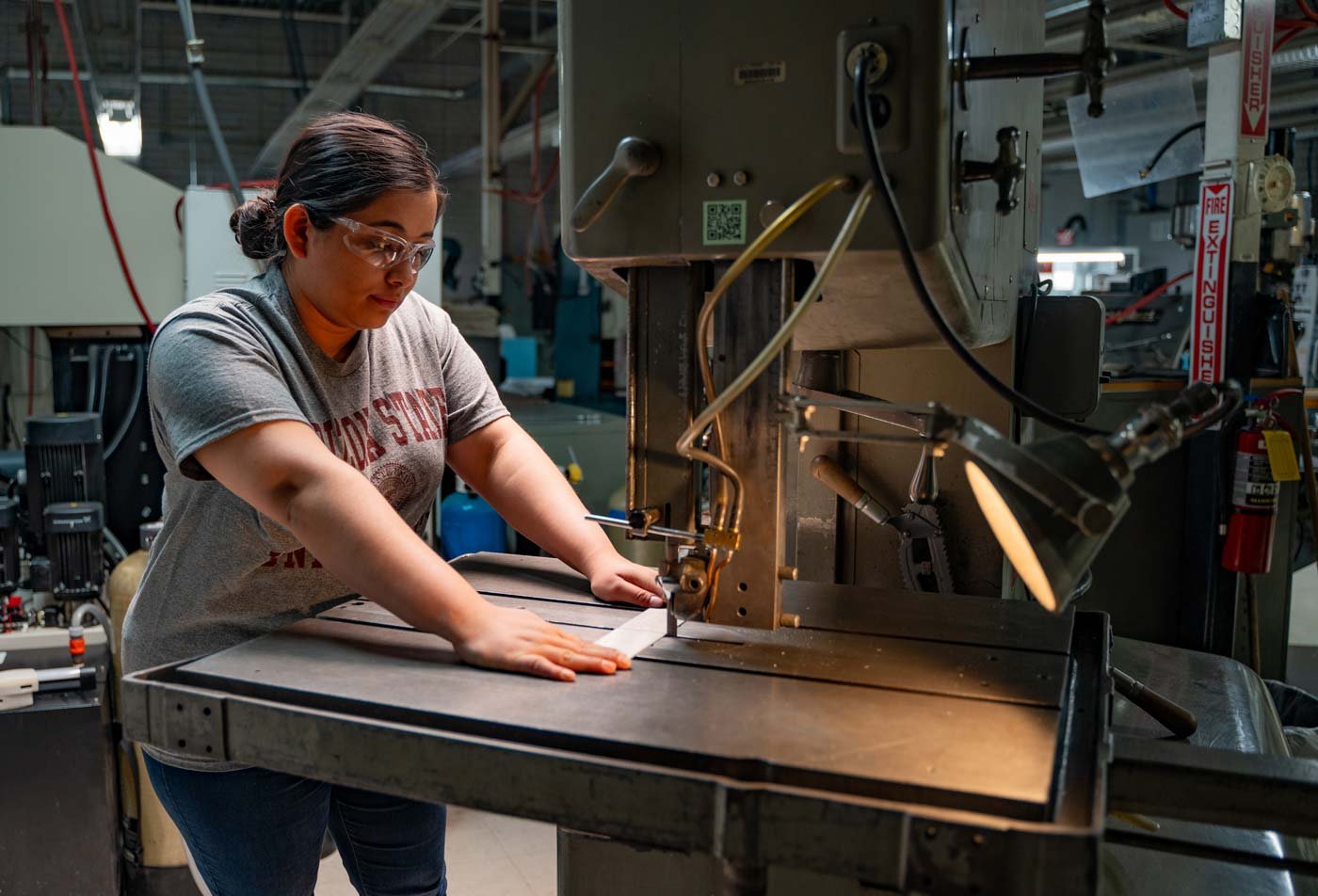 A student operates industrial equipment in a manufacturing lab, demonstrating advanced research in ASU's Industrial Engineering, PhD program.