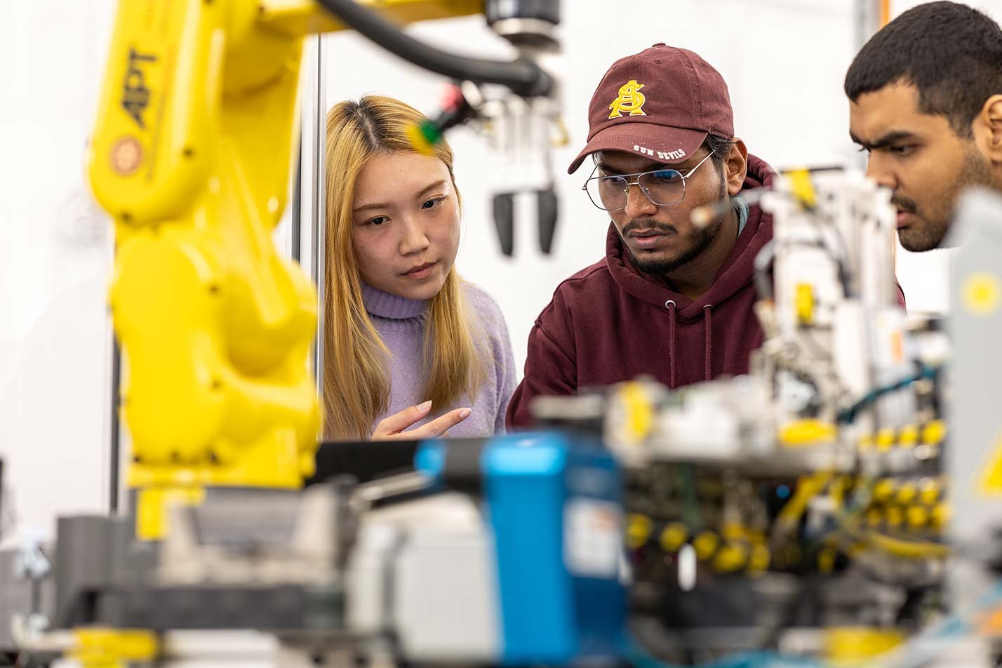 Researchers handle precision electronic equipment, highlighting applied technology in ASU's Learning Engineering (Graduate Certificate).