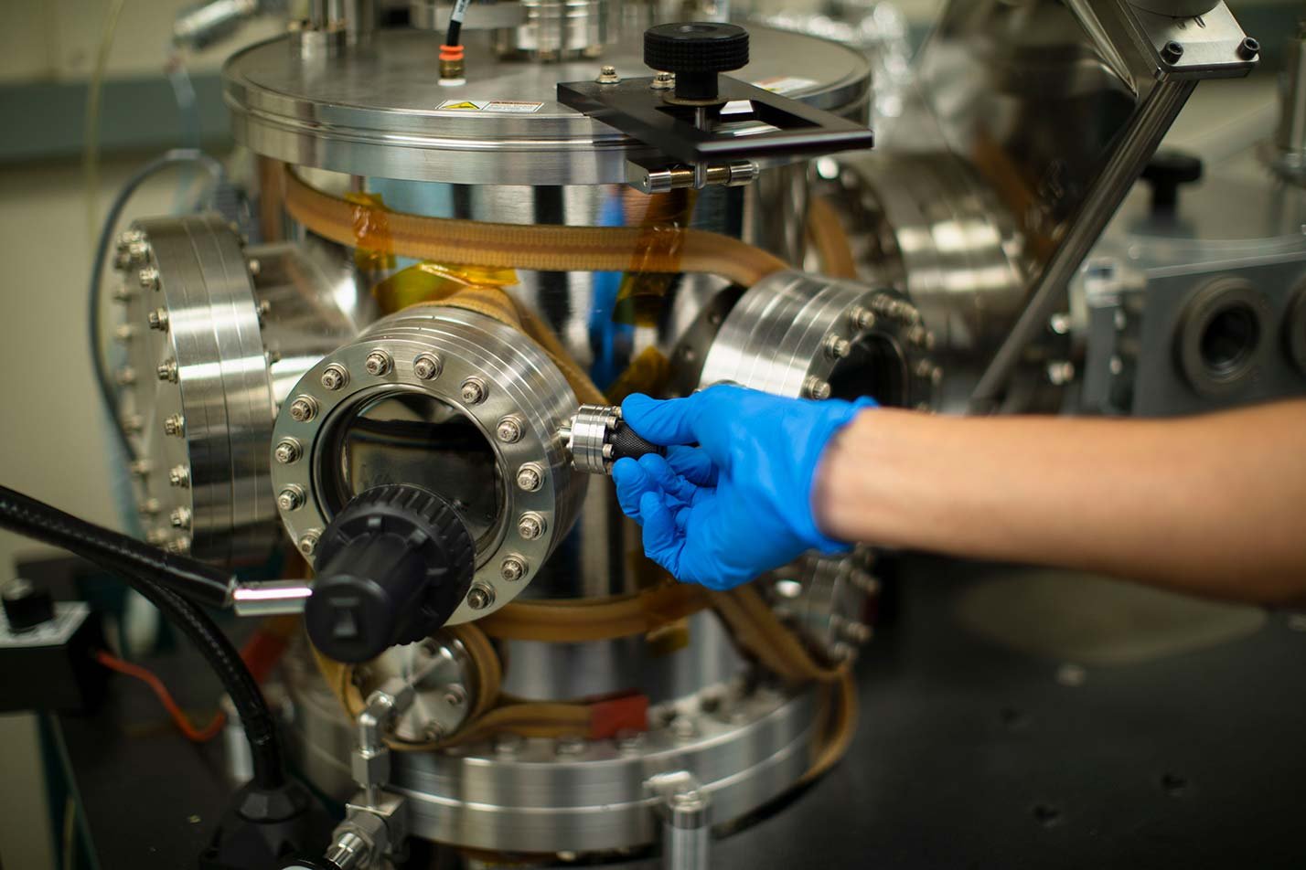 A researcher adjusts precision scientific instrumentation, reflecting doctoral research in ASU's Mechanical Engineering, PhD program.