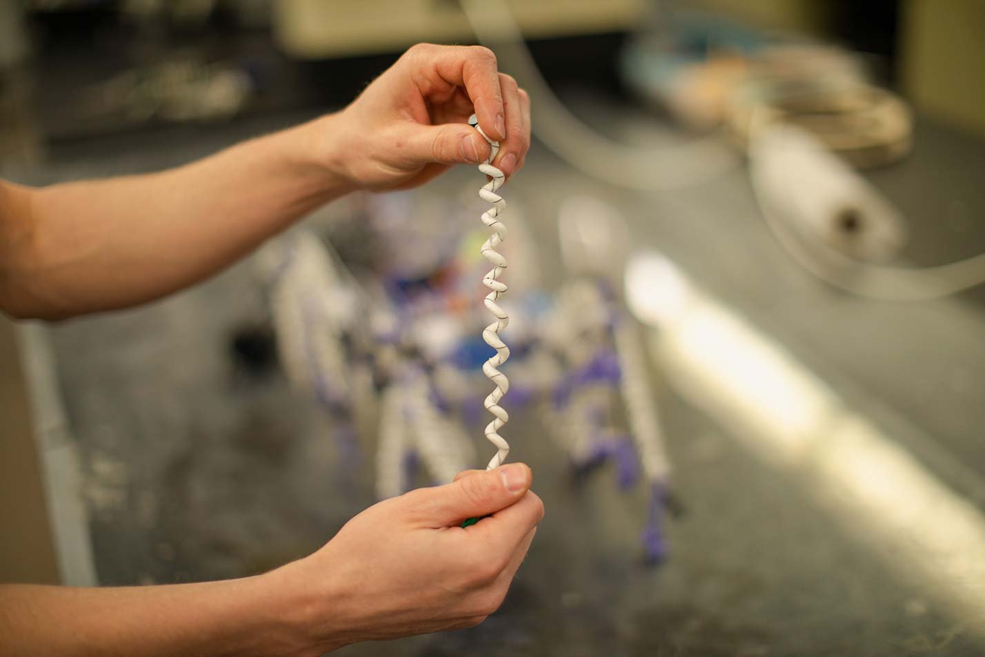 A hand holds coiled material above a workbench, showcasing hands-on experimentation in ASU's BSE in Materials Science and Engineering program.