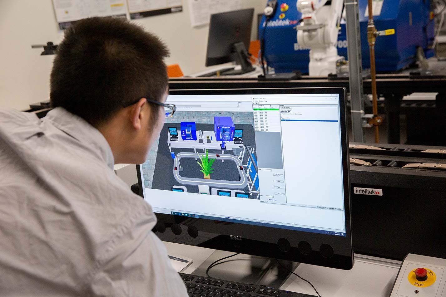 A researcher monitors an automated manufacturing simulation, showcasing systems optimization in ASU's Systems Engineering, PhD program.