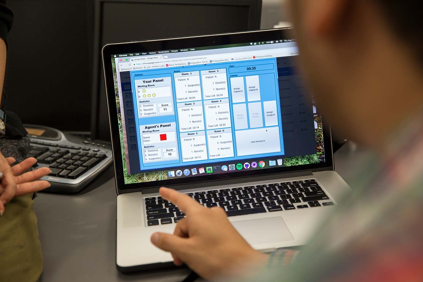 A laptop displays workflow software, highlighting systems research in ASU's Human Systems Engineering, PhD program.