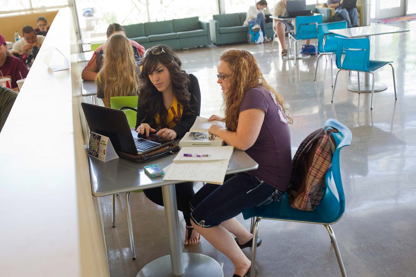 Two students hold a collaborative study session at a table, highlighting teamwork in ASU's Technological Entrepreneurship and Management program.