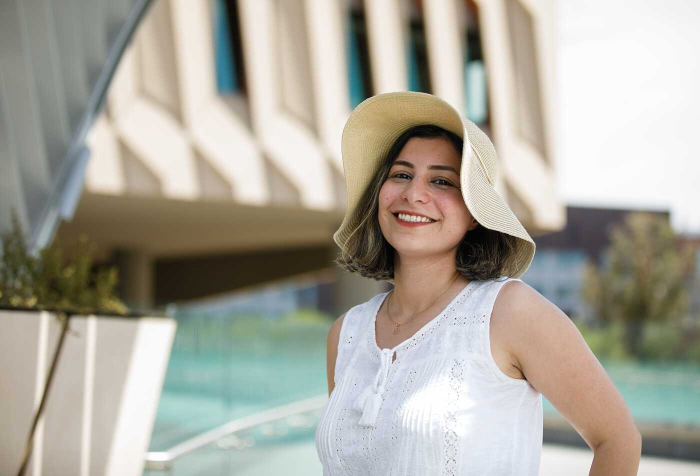 Arizona State University doctoral student smiles outside the Rob and Melani Walton Center for Planetary Health on the Tempe Campus.