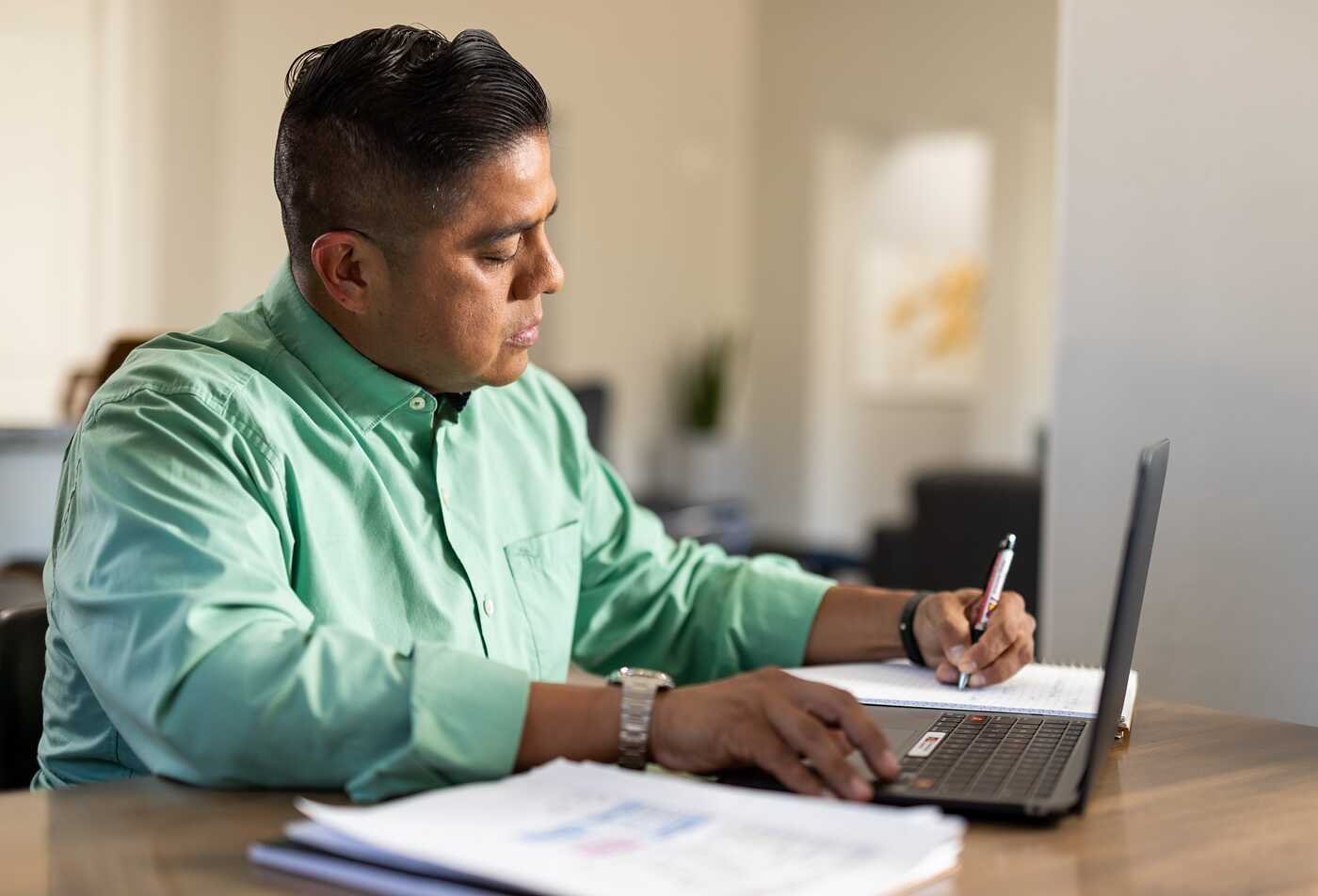 A Nonfiction Writing and Publishing student puts his studies to practice as he writes in a notebook.