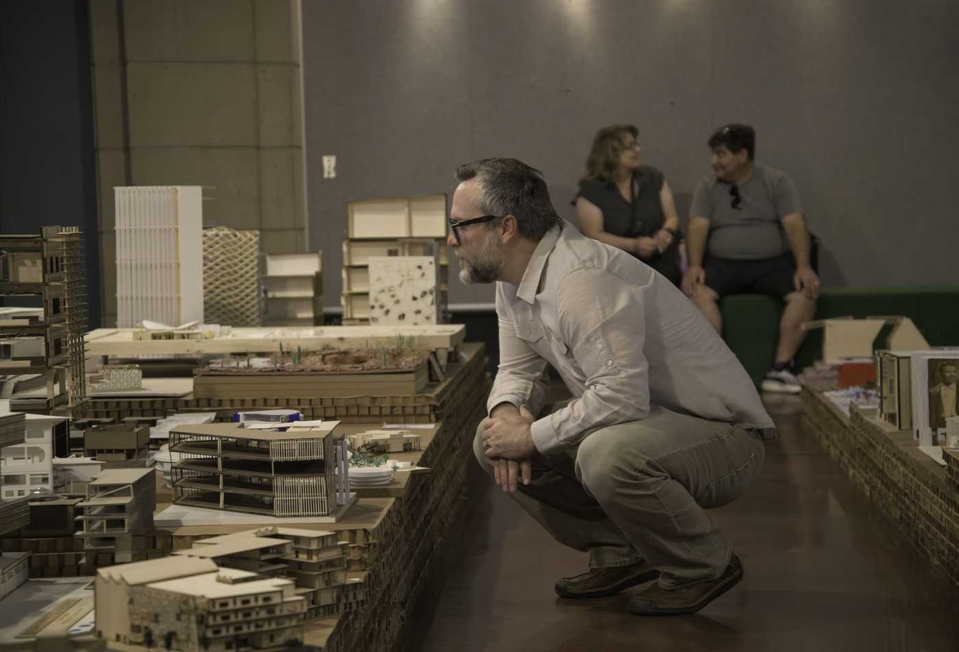 A professor examines models created by an architecure students, reflecting hands-on learning in the Architecture, MArch