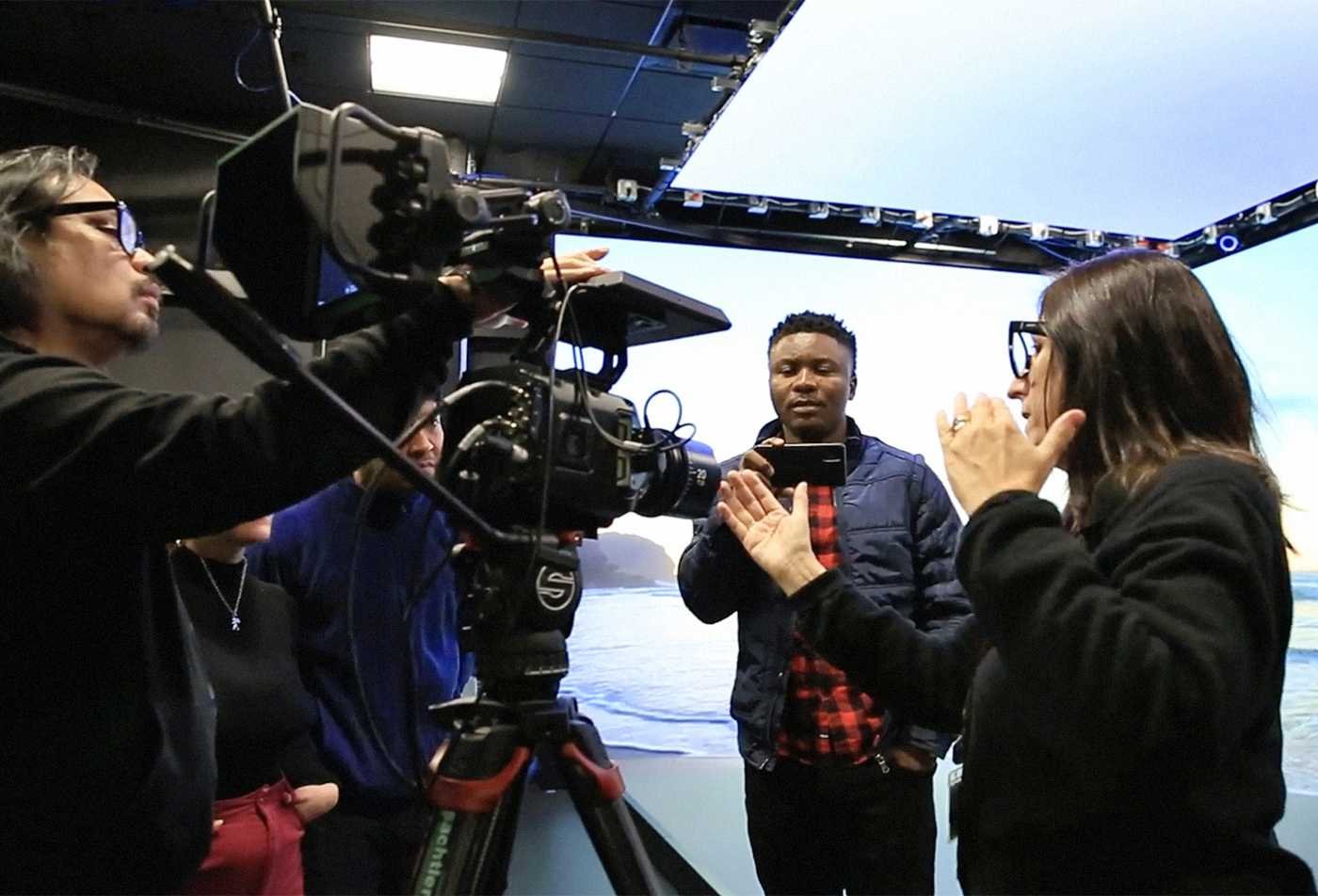 Students film an interview in a professional studio, showcasing hands-on learning in the Narrative and Emerging Media, MA.