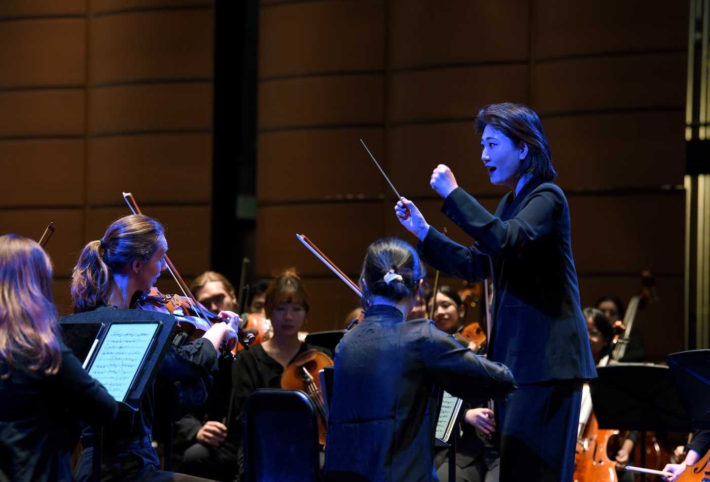 A orchestra plays together, showcasing the field explored in the Conducting, DMA.