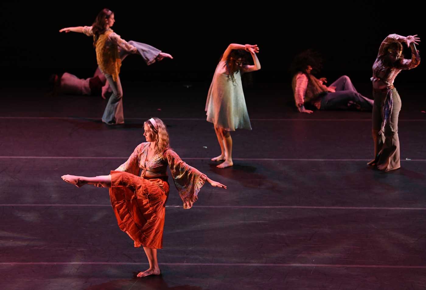 Students dance on a theatrical stage, demonstrating the field explored in the minor in Dance.