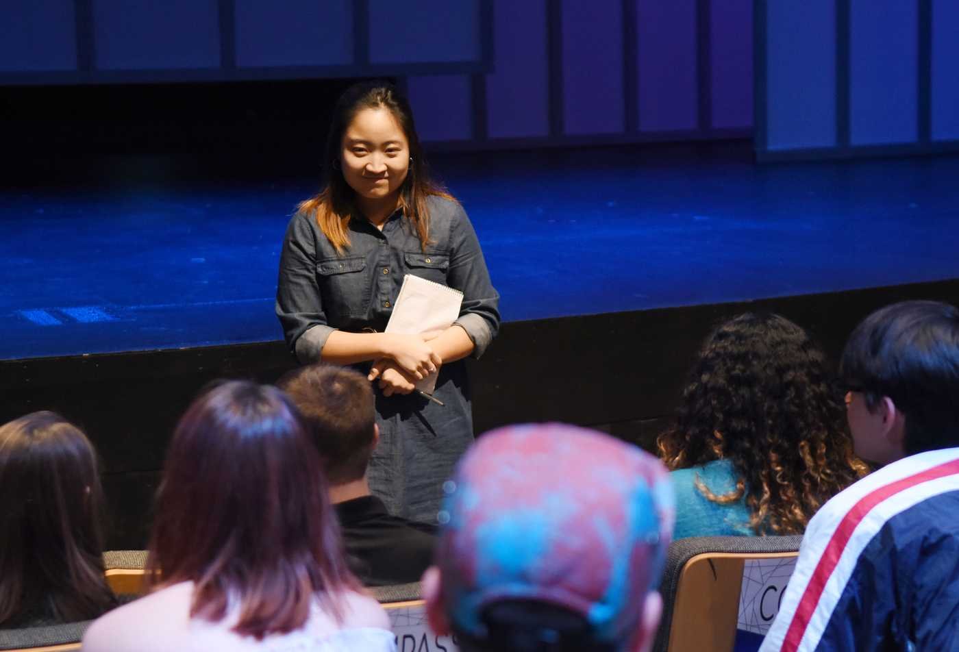A theater director speaks to production cast and crew, showcasing hands-on learning in the Theatre (Directing), MFA.