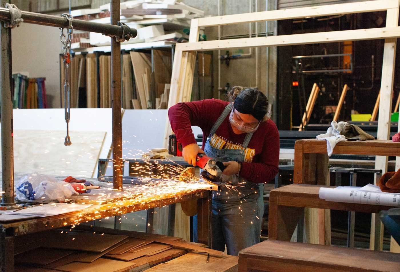 A student builds a set for a production, reflecting hands-on learning in the BA in Theatre (Design and Production).