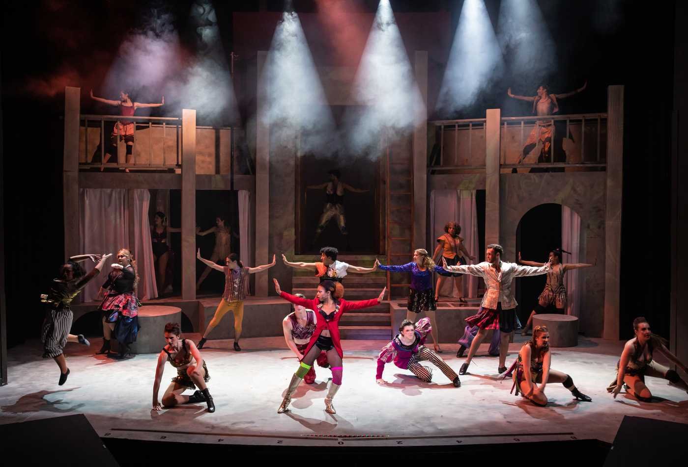Students dance on a theatrical stage, demonstrating the field explored in the BMUS in Performance (Music Theatre).