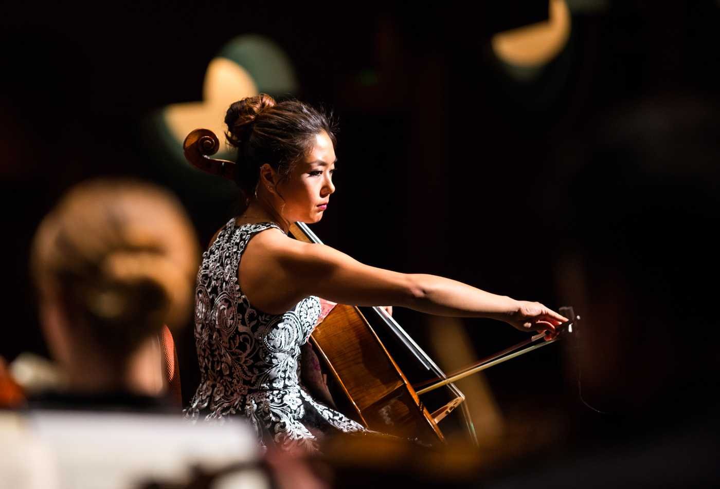 A professional plays a cello on stage, demonstrating the expertise gained in the Music (Performance), DMA.