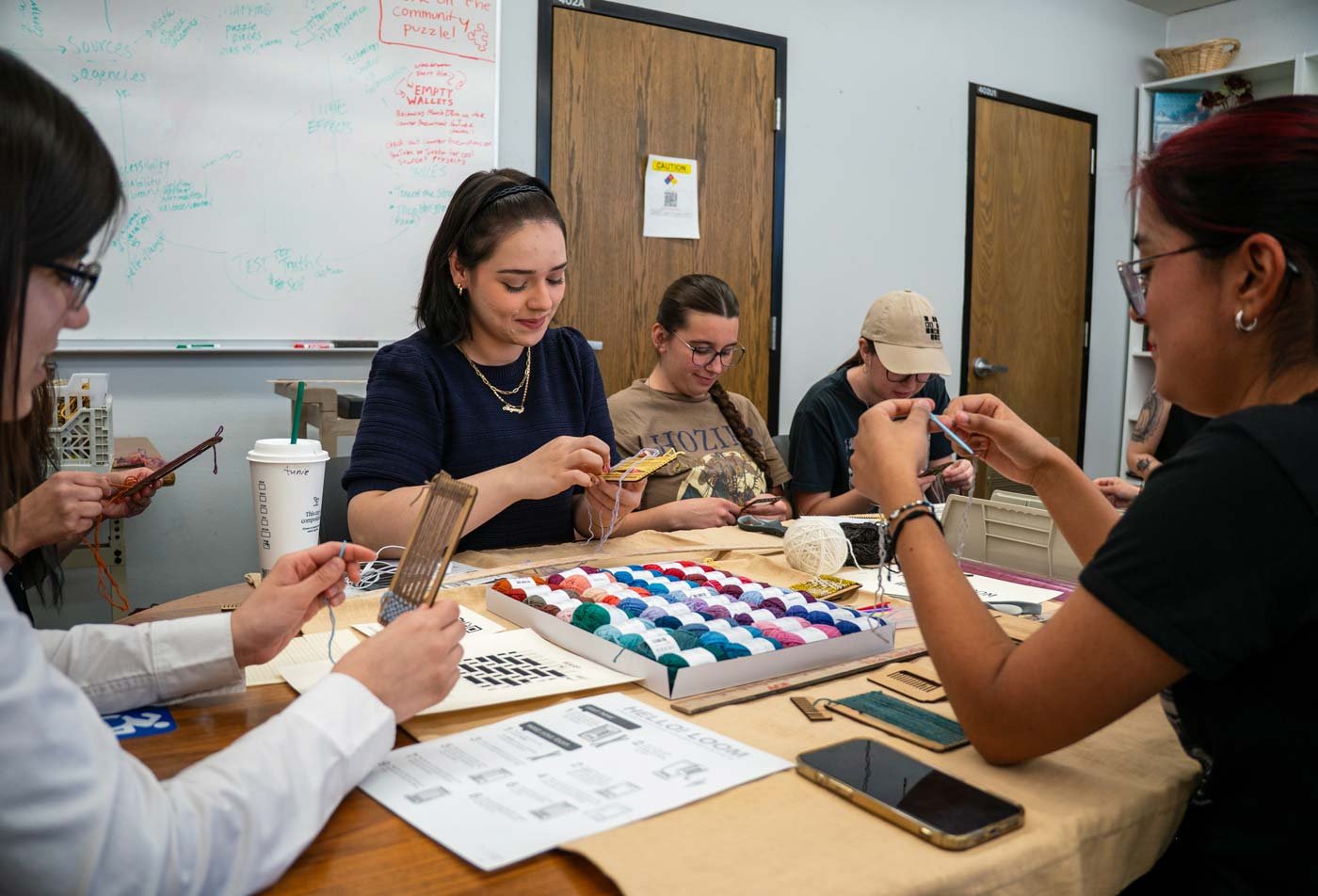 Students weave together, reflecting hands-on learning in the certificate in Arts in Education.