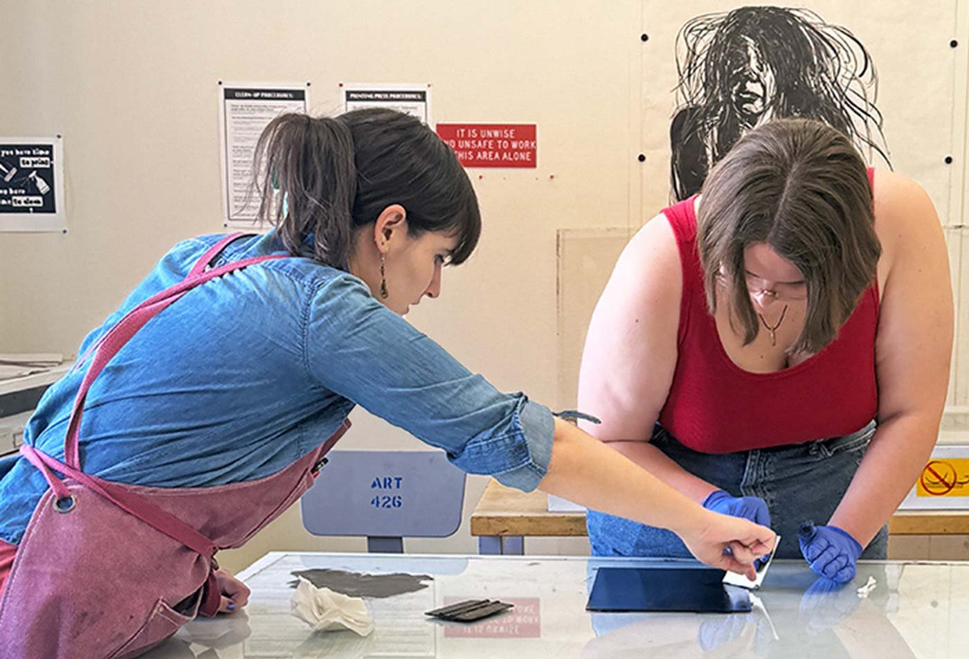 Students collaborate on a printmaking project together, demonstrating hands-on learning in the BFA in Art (Painting, Drawing and Printmaking).