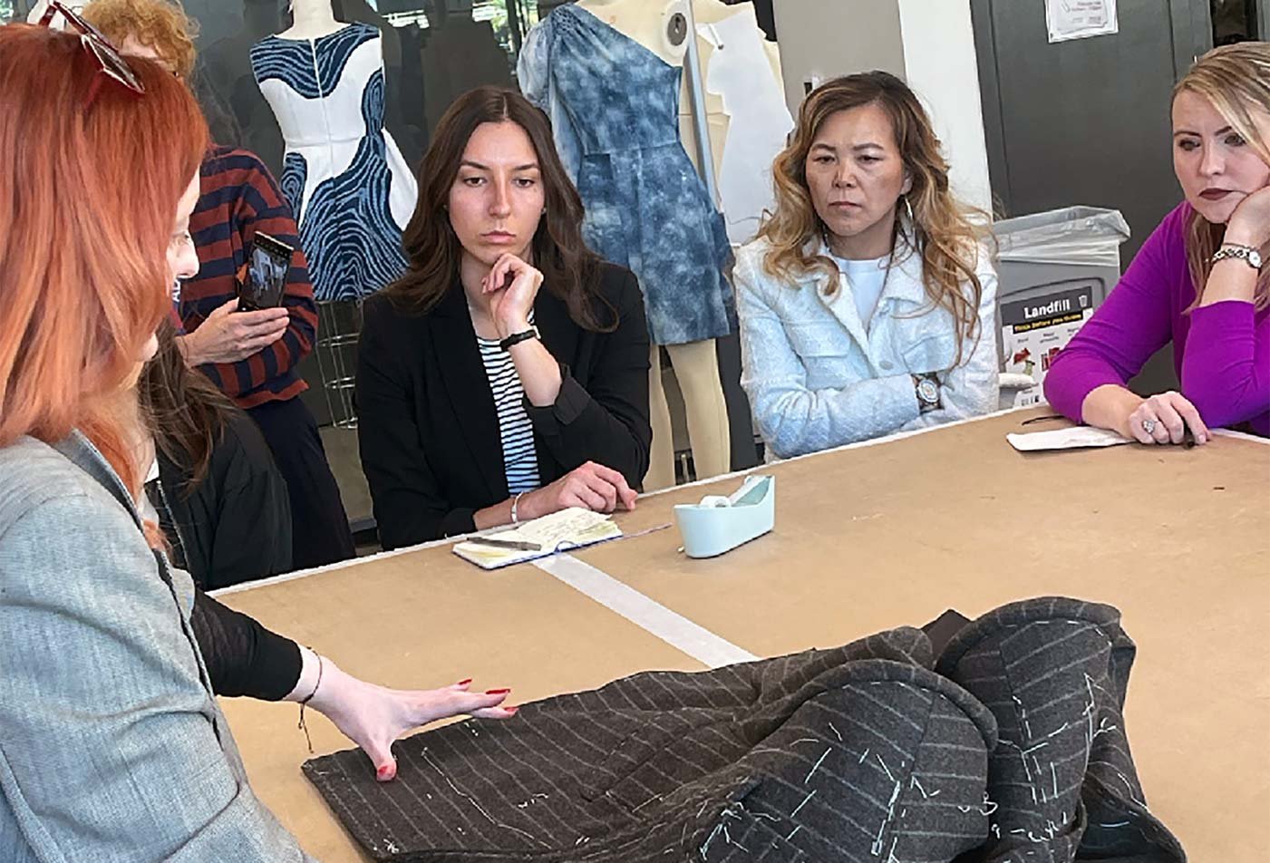 A class reviews the tailoring of a jacket, reflecting hands-on learning in the certificate in Bespoke Tailoring.