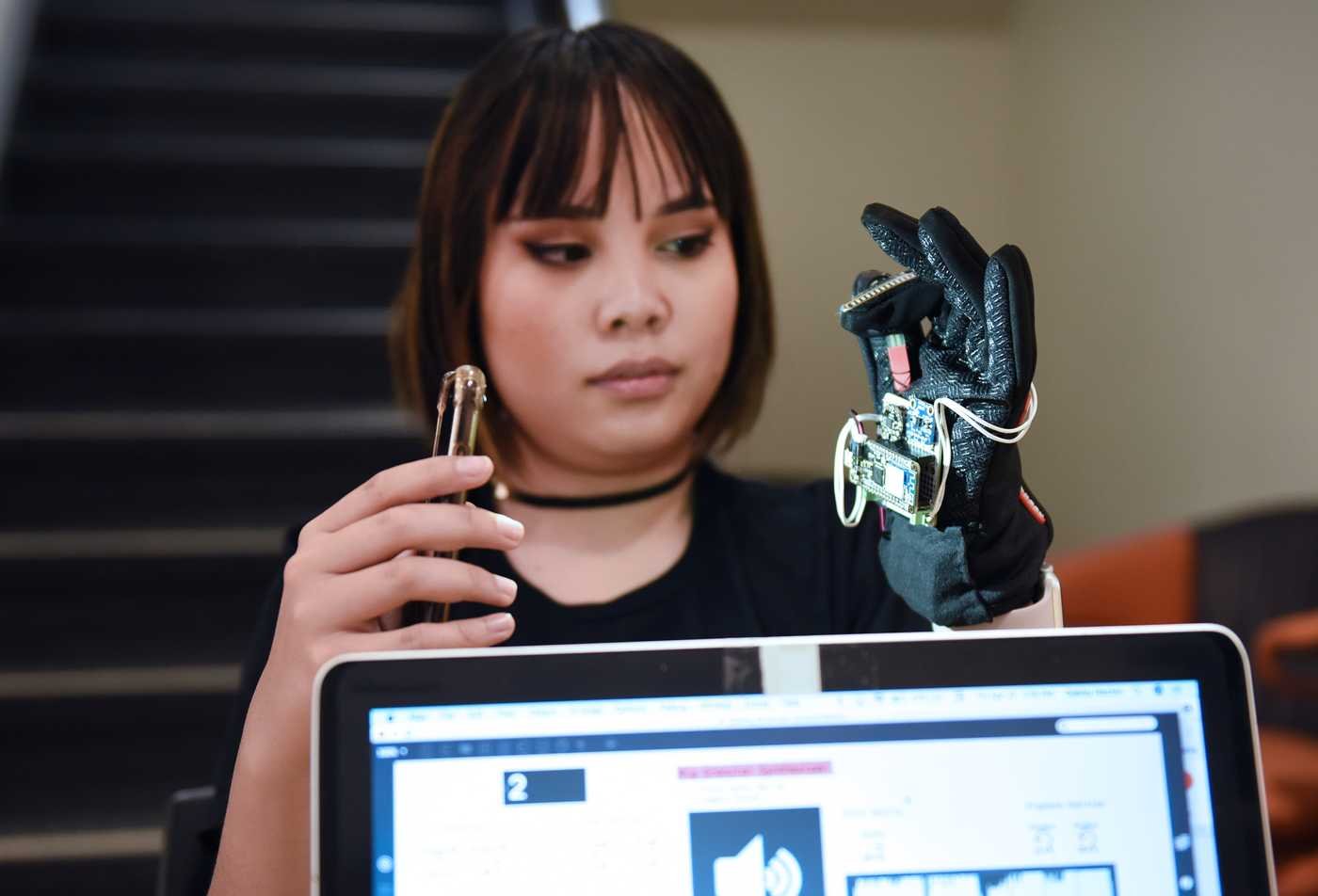 A student uses a haptic glove, demonstrating hands-on learning in the BS in Media Arts and Sciences (Media Processing)