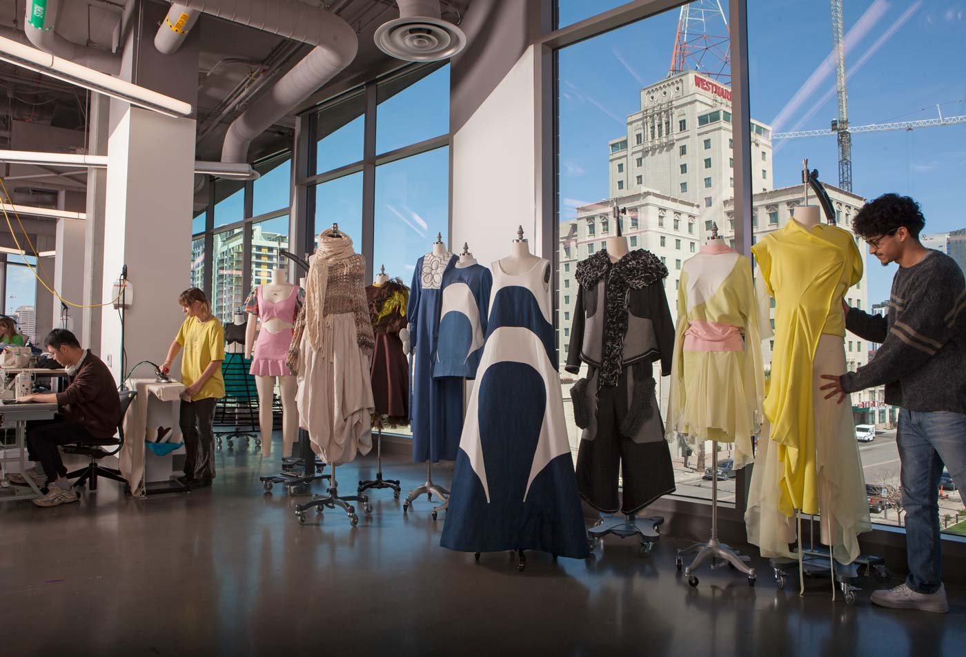A row of dress forms featuring designs created by fashion students demonstrates the field explored in the BA in Fashion.