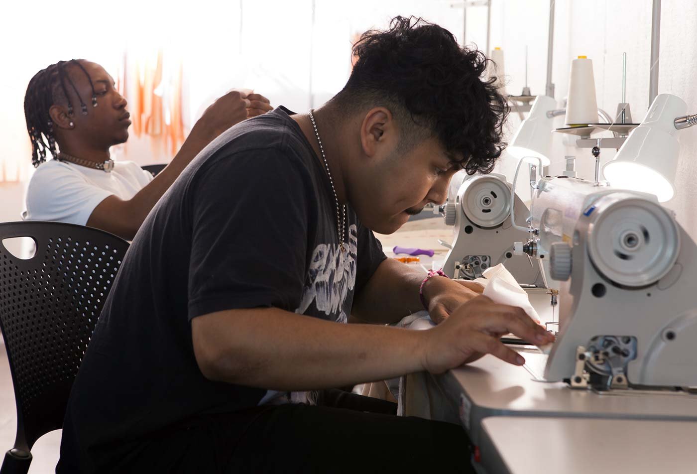 Students work on sewing machines, reflecting hands-on learning in the minor in Fashion.