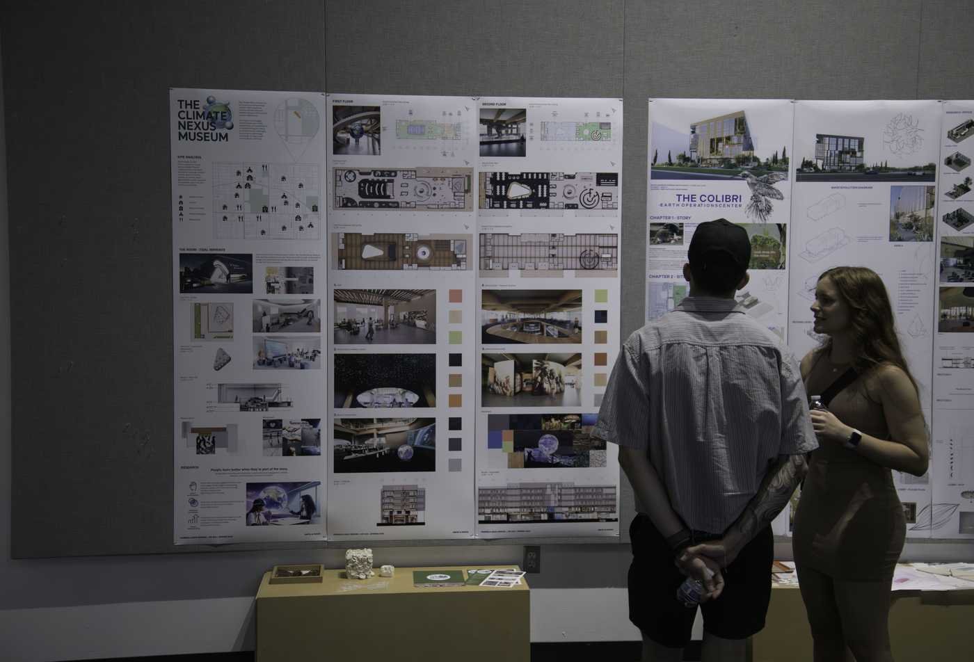 Two students explore displays of interior design, demonstrating hands-on learning in the Interior Architecture, MIA.