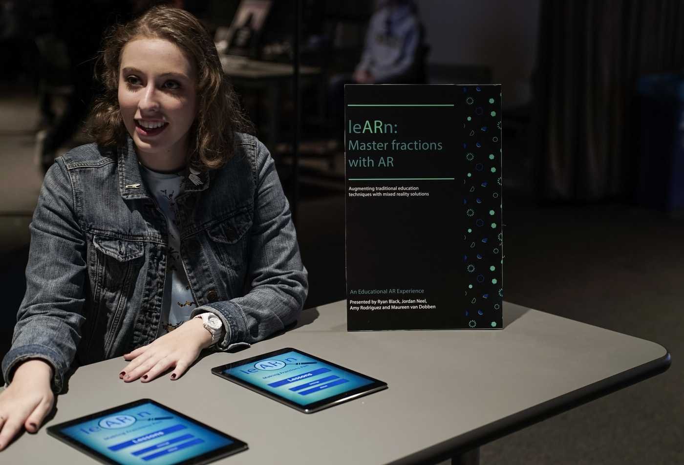 A student shows her project about learning fractions with AR, demonstrating the field explored in the BA in Media Arts and Sciences (Education).