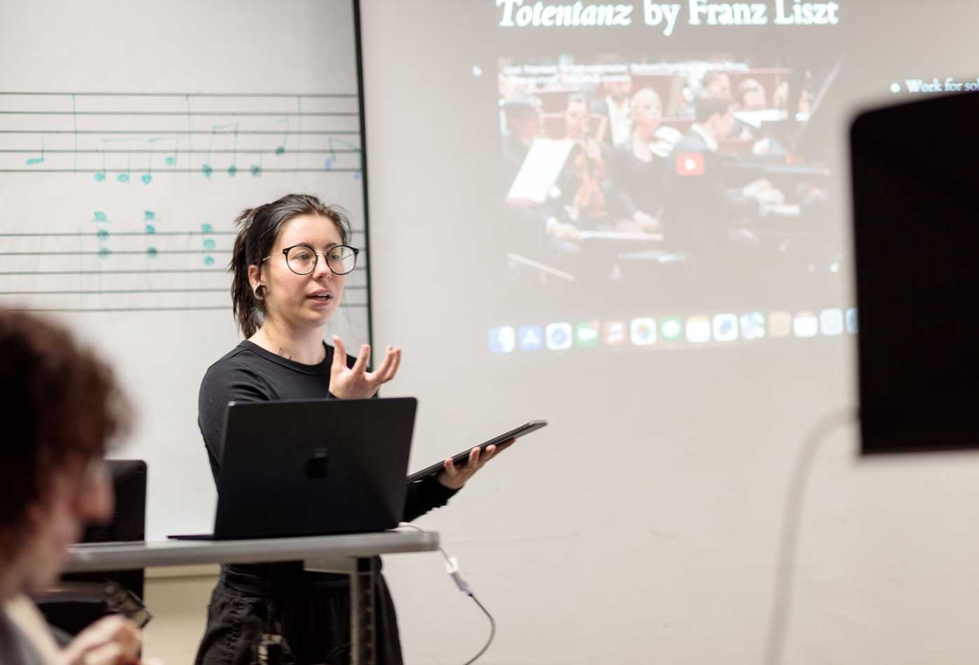 A professor explains musical theory in the Music (Musicology), PhD.