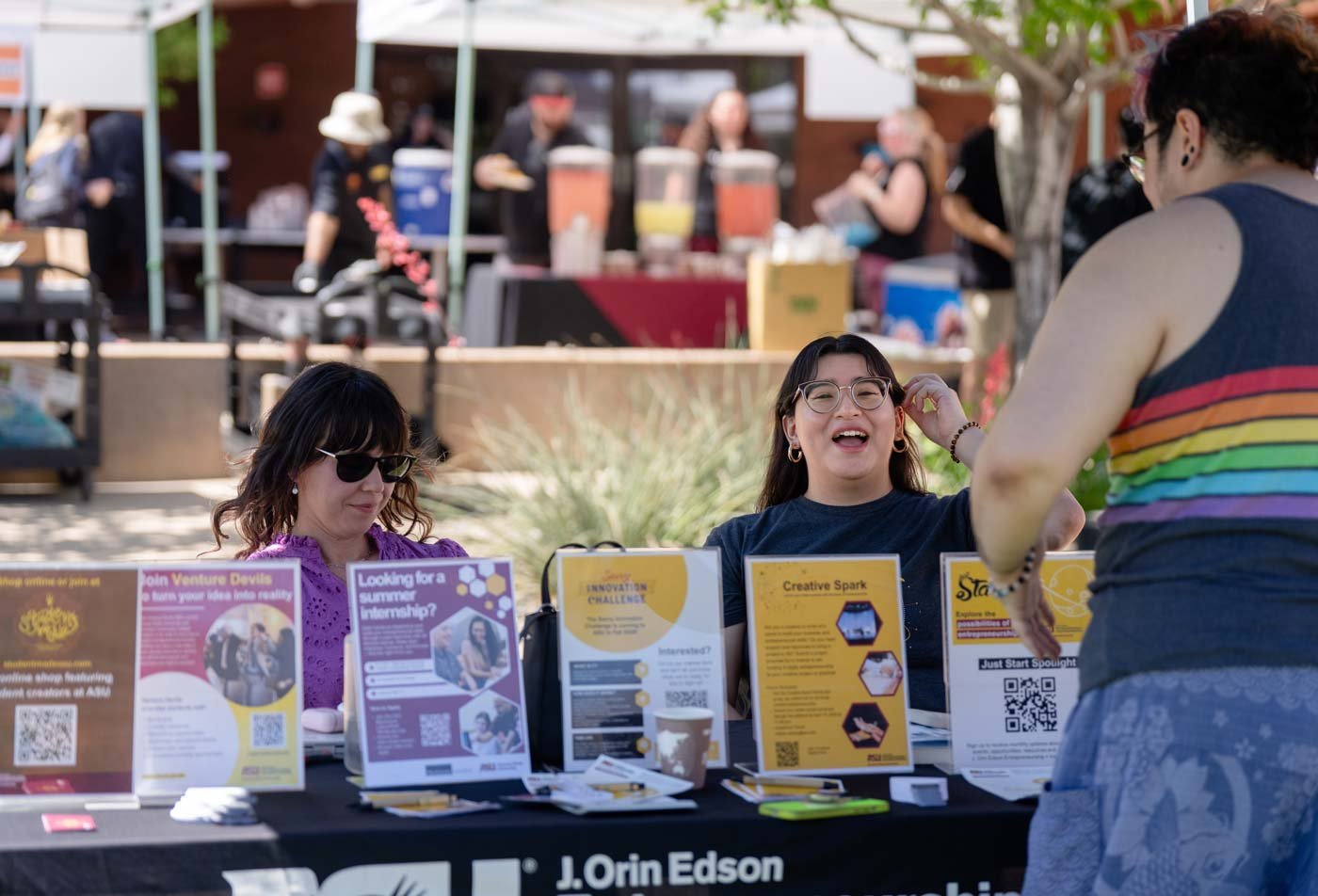 Students man a table at a community event, reflecting community involvement in the certificate in Community-Engaged Practices in Design and the Arts (Graduate Certificate).