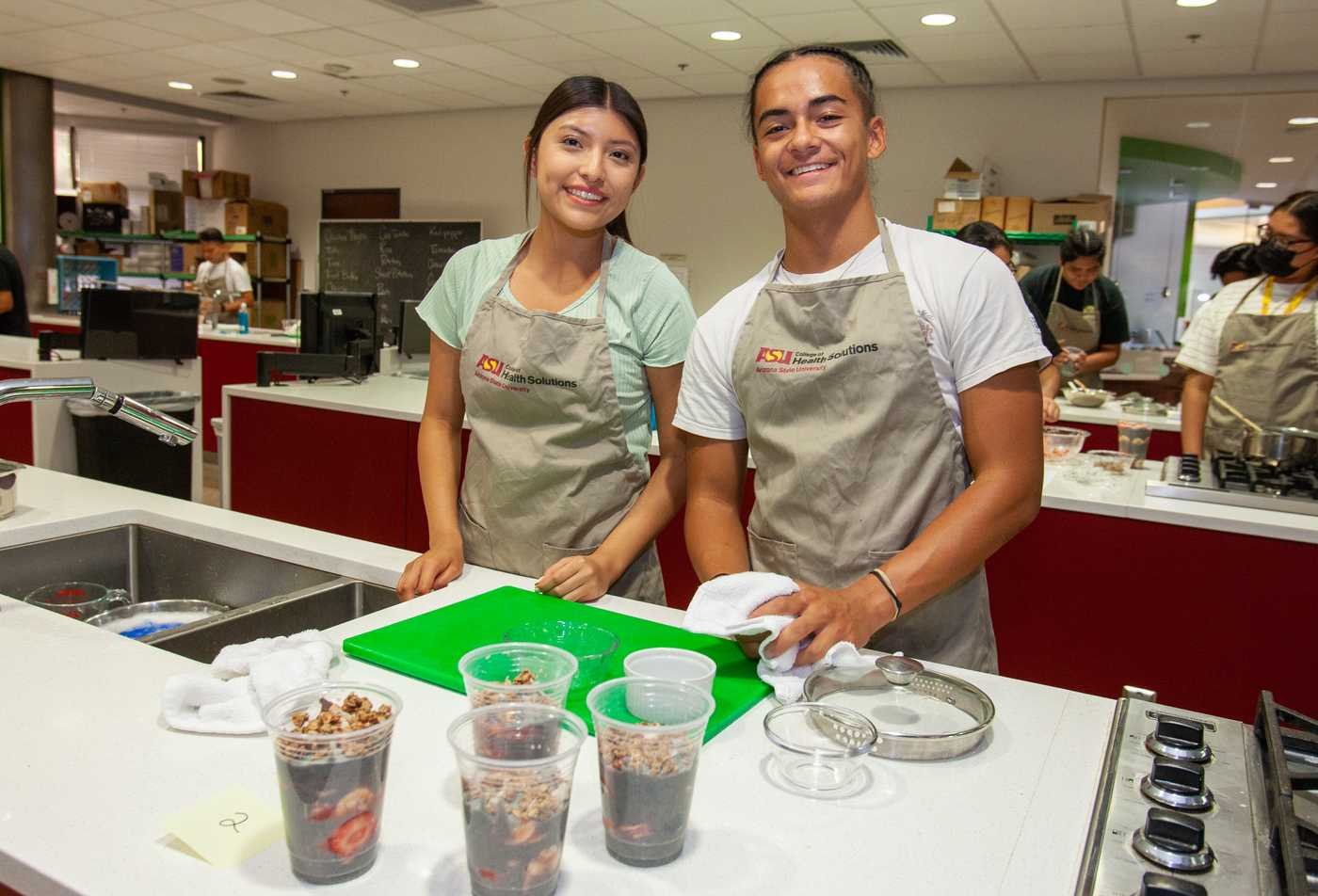 Two young adults in a kitchen preparing food, surrounded by ingredients and utensils, exploring the skills examined in the minor in Food and Nutrition Entrepreneurship.
