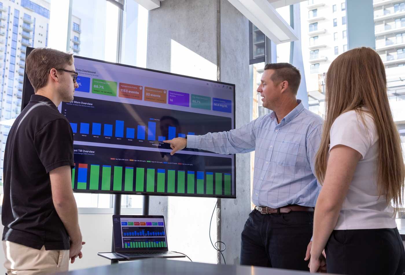 An instructor uses a digital display to explain biomedical data to students, highlighting collaborative learning in the BS in Biomedical Informatics and Data Science.