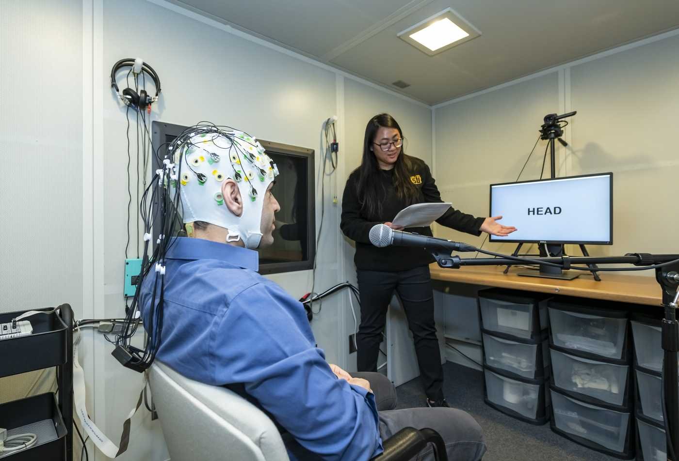 A researcher neruosciences experiements with a partipant, demonstrating the hands-on research explored in the MS in Auditory and Language Neuroscience.