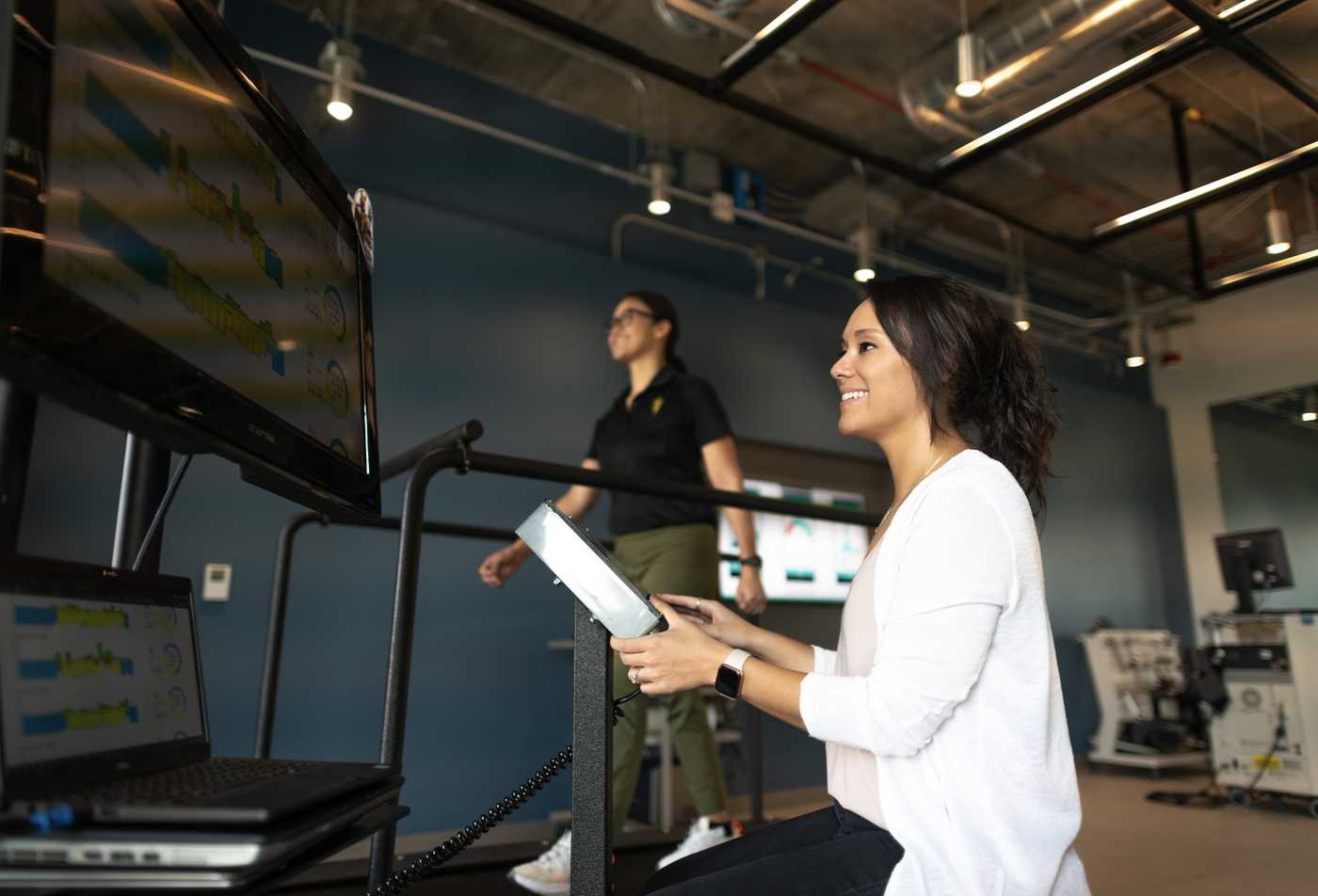 A researcher conducts an experiment with exercise equipment, demonstrating the hands-on research explore in the MS in Clinical Exercise Physiology.