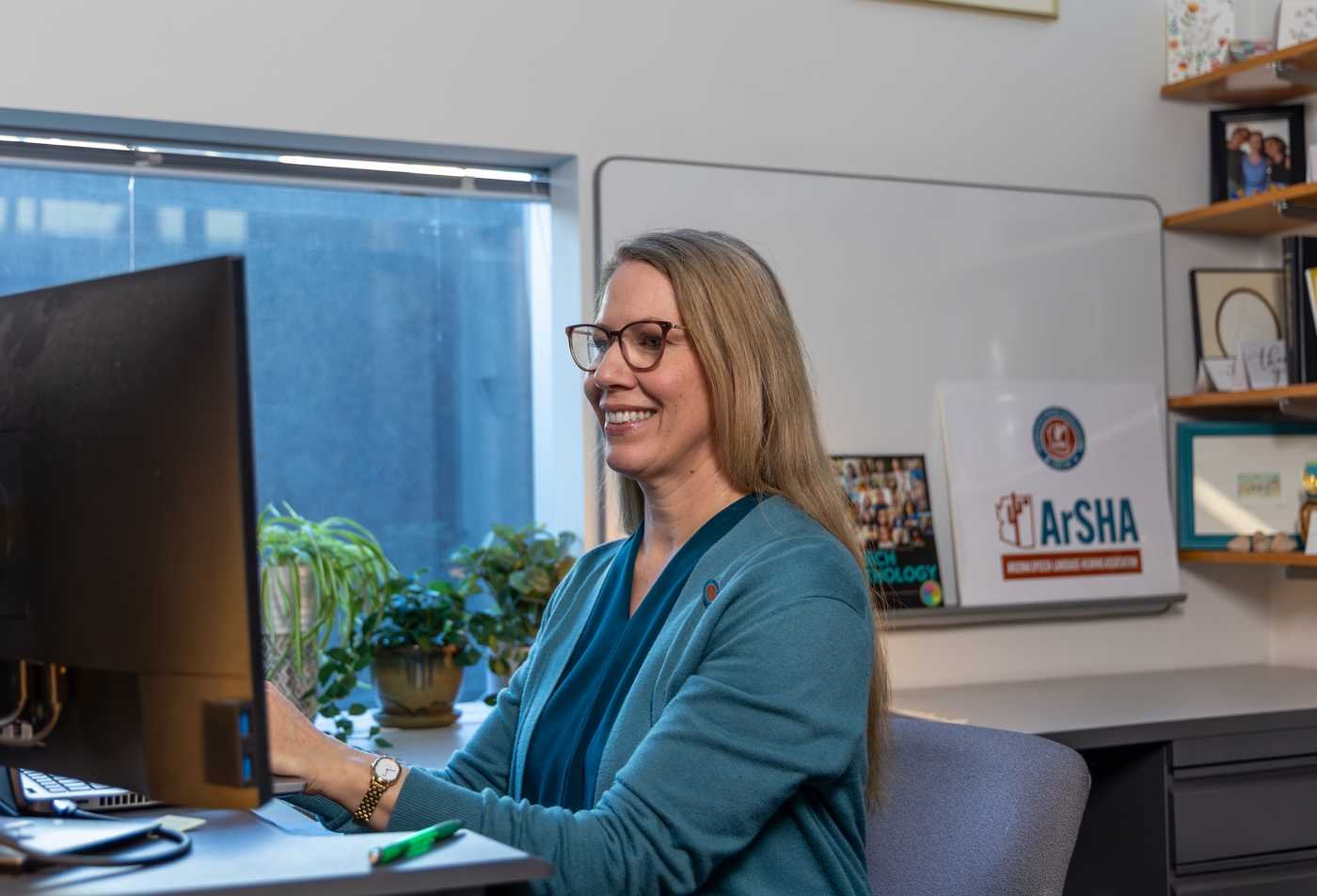 A health professional works on a computer in an office, demostrating expertise gained in the certificate in Integrated Behavioral Health - Clinical.