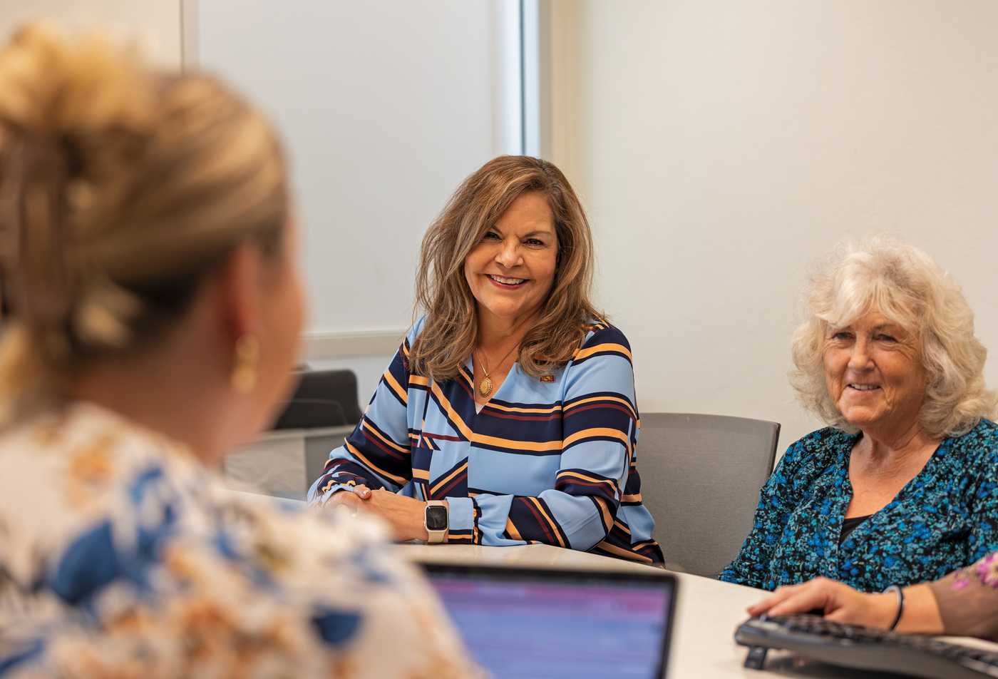 A group of women meet at a table, discussing health strategies in the certificate in Integrated Behavioral Health - Management.