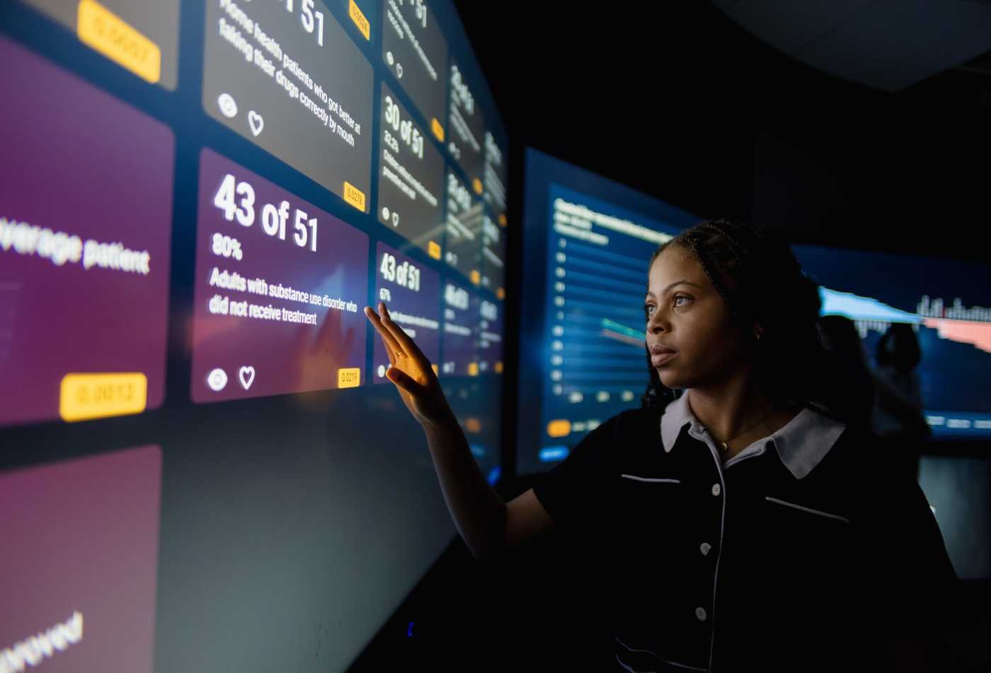 A student examines data in on a digital display in the Decision Theater, showcasing the hands-on learning in the BS in Population Health.