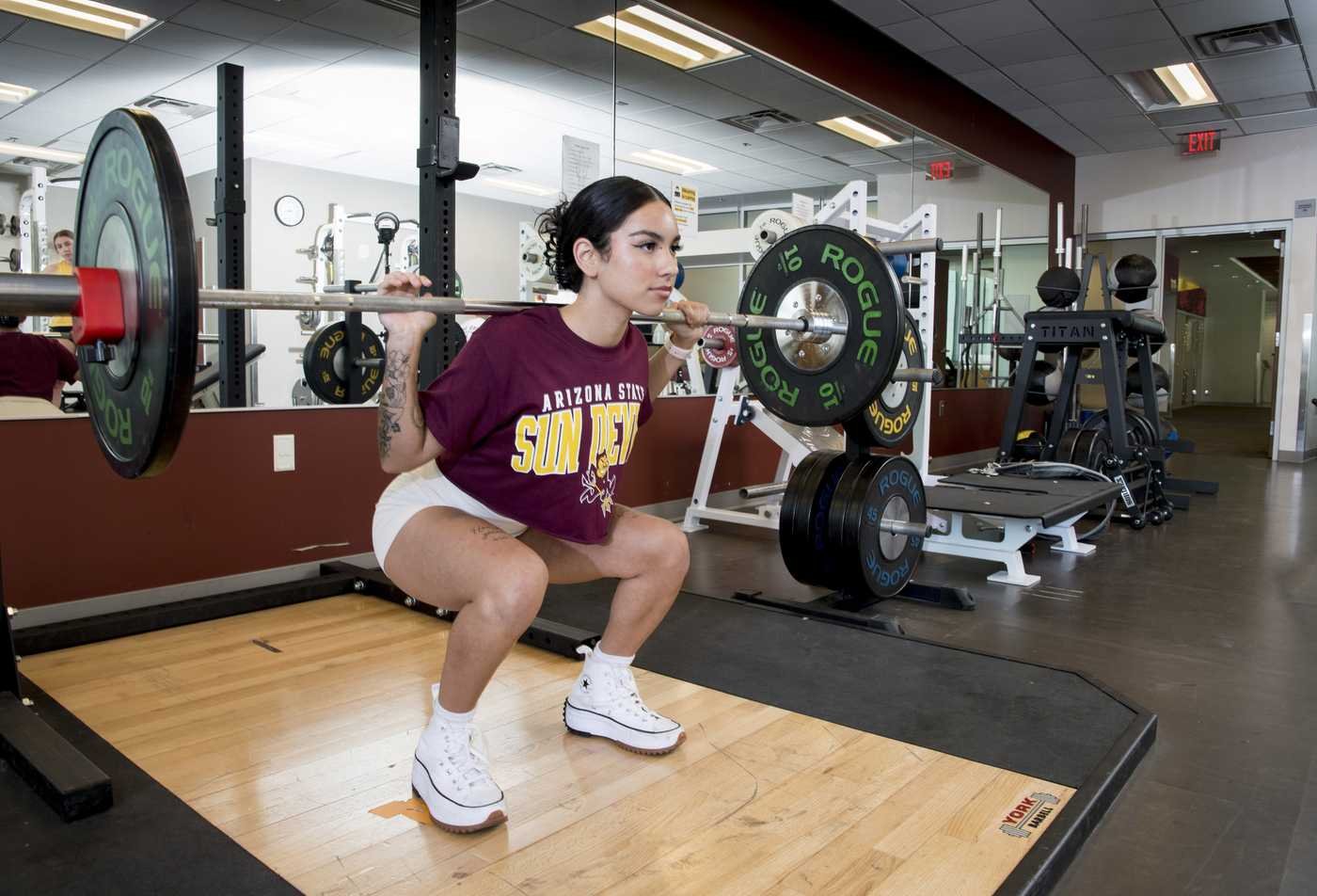A student performs a squat with a barbell on their shoulders, demonstrating the skills explored in the BS in Sports Science and Performance Programming (Strength and Conditioning).
