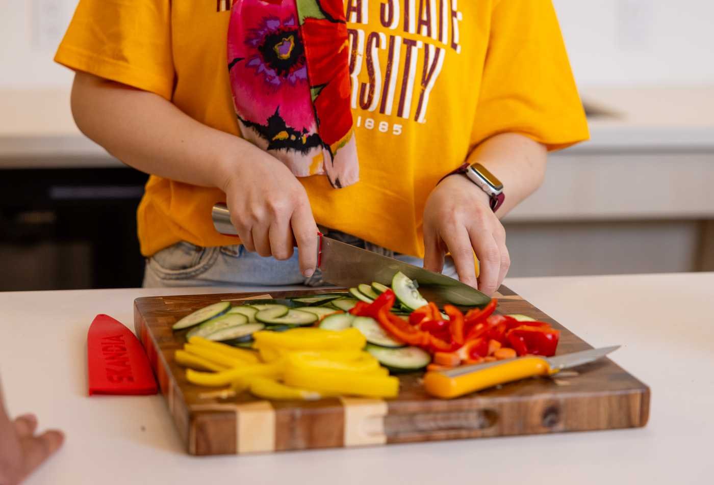 A student prepares zucchini and peppers, displaying the health principles explored in the minor in Nutrition and Healthy Living.