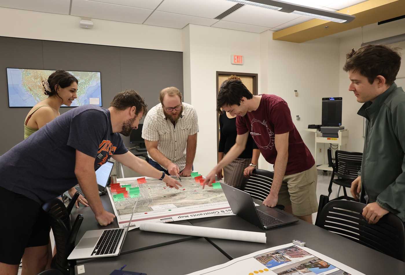 Students collaborate around a large map with sticky notes during a planning classroom activity, demonstrating collaborative, hands-on learning BSP in Urban Planning.