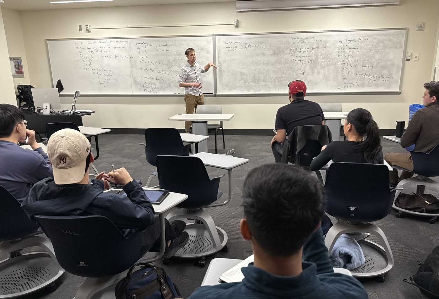 A classroom watches a professor explain statistics in the certificate program in Actuarial Science.
