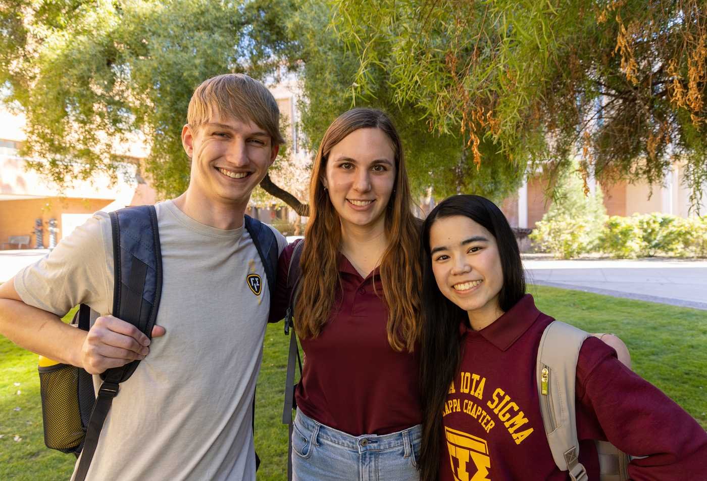 Three students smile at the camera, showing the collaborative learning environment of the MS in Actuarial Science.