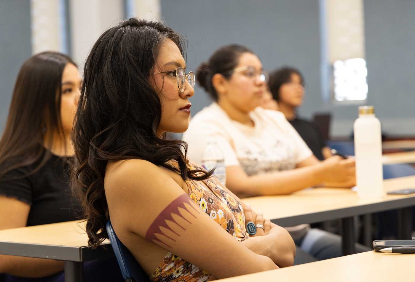 A student listens attentively in a classroom, showcasing the focused learning in the MS in American Indian Studies.