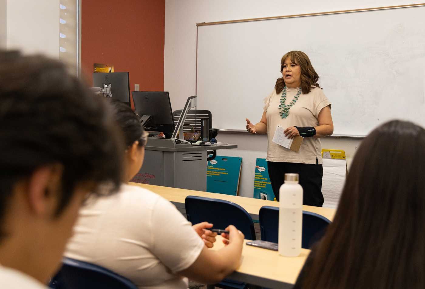 A professor standing in the front of the classroom, demonstrating expertise gained in the MS in American Indian Studies (Tribal Leadership and Governance).