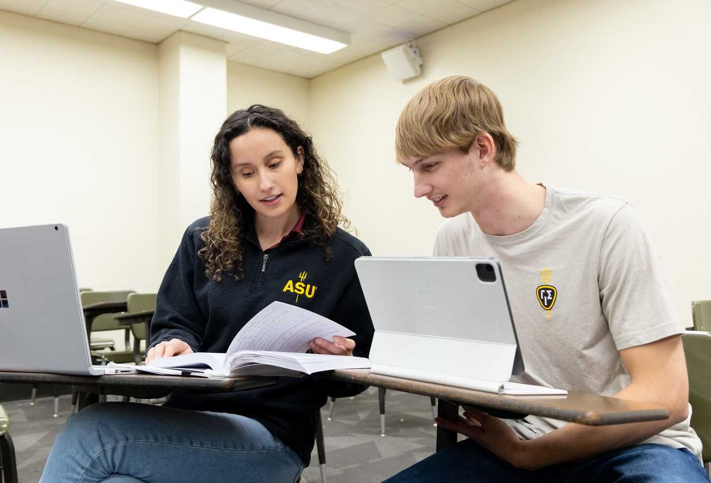 Students share notes in a classroom, showcasing collaborative learning in the certificate in Analysis and Management of Insurance Risk.