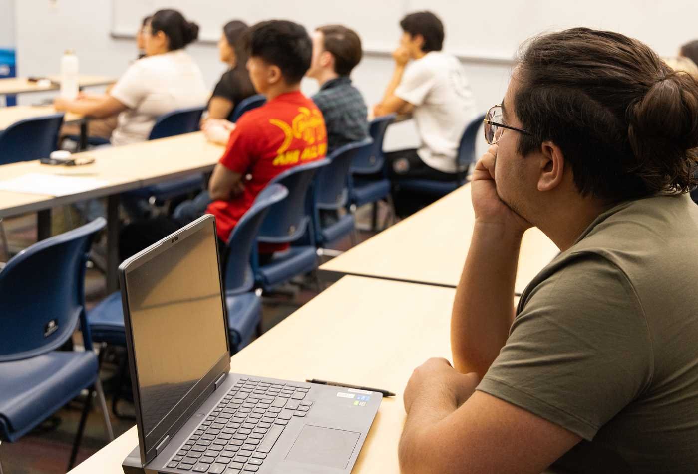 A student focuses in class with his laptop open ready to take notes, demonstrating focused learning in the certificate in American Studies.