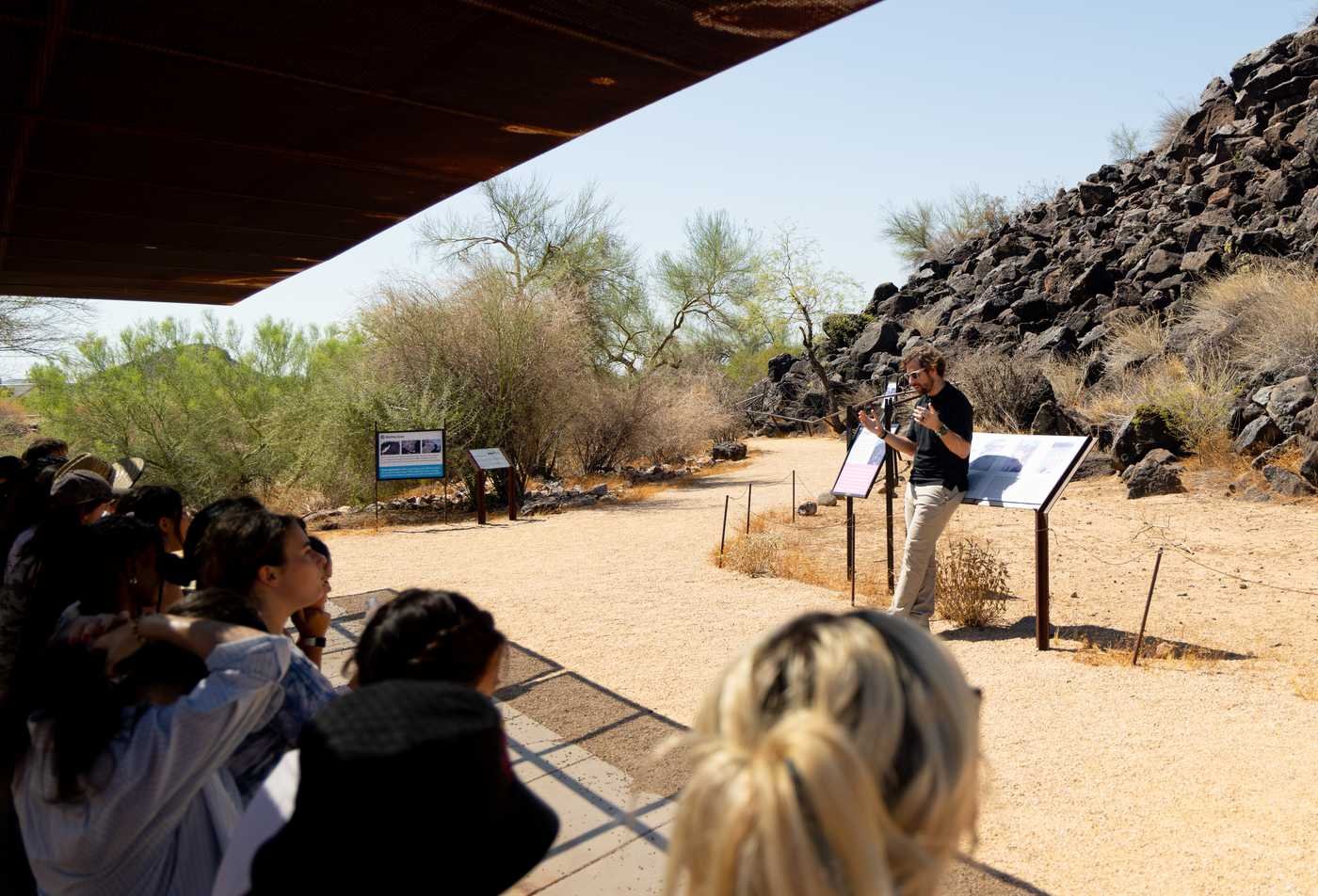 A professor teaches a class in front of a historical site, showcasing the field explored in the PhD in Anthropology (Complex Adaptive Systems Science).