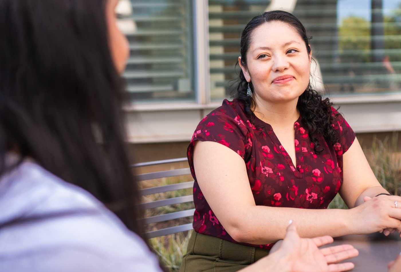 Applied behavior analysis student and psychology faculty member Lorraine Becerra talking outdoors on campus, showcasing the collaborative learning in the MS in Applied Behavior Analysis.
