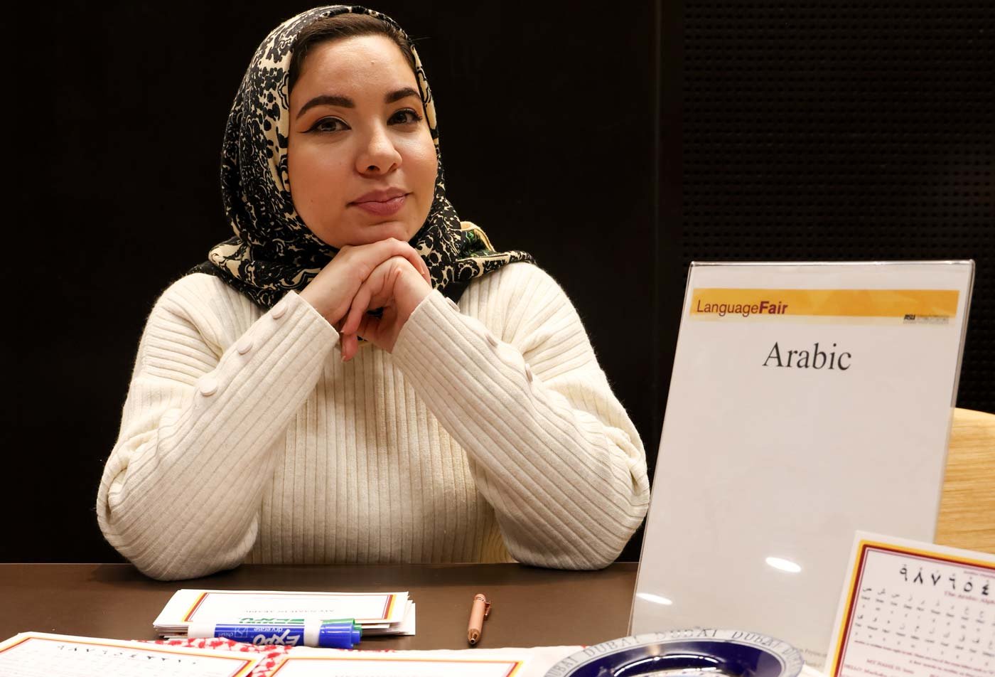 A student presents at a table showcasing Arabic cultural artifacts, demonstrating the expertise gained in the minor in Arabic Studies.